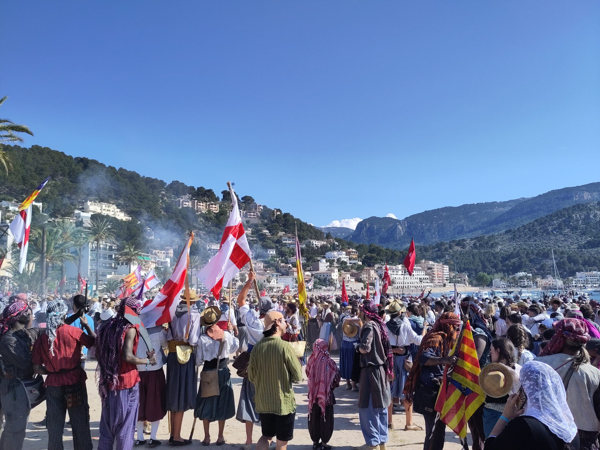 Verkleidete Teilnehmer mit Fahnen beim Firó de Sóller am Strand von Port de Sóller